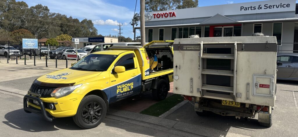 Rapid Fuel Assist technician draining wrong fuel from a vehicle at a Toyota dealership service department