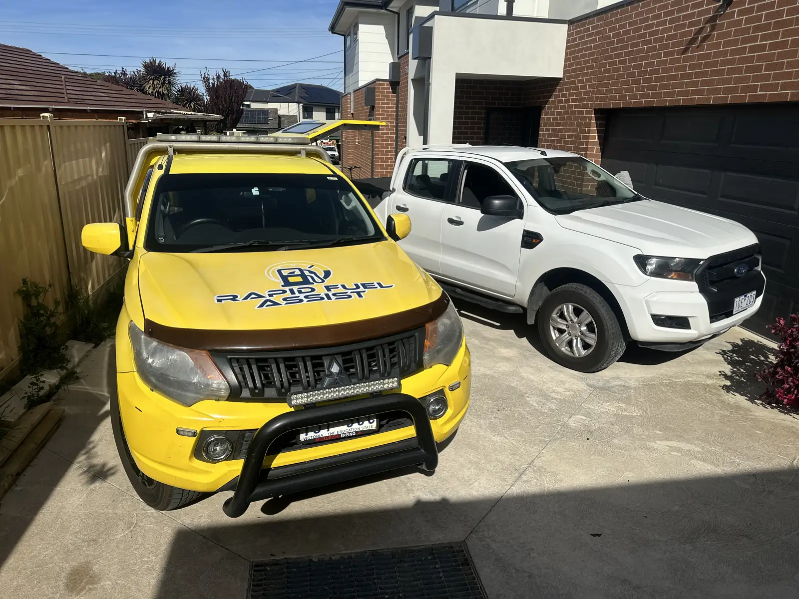 White diesel Ford Ranger with petrol in the tank, parked in a Doveton driveway beside the yellow Rapid Fuel Assist service ute