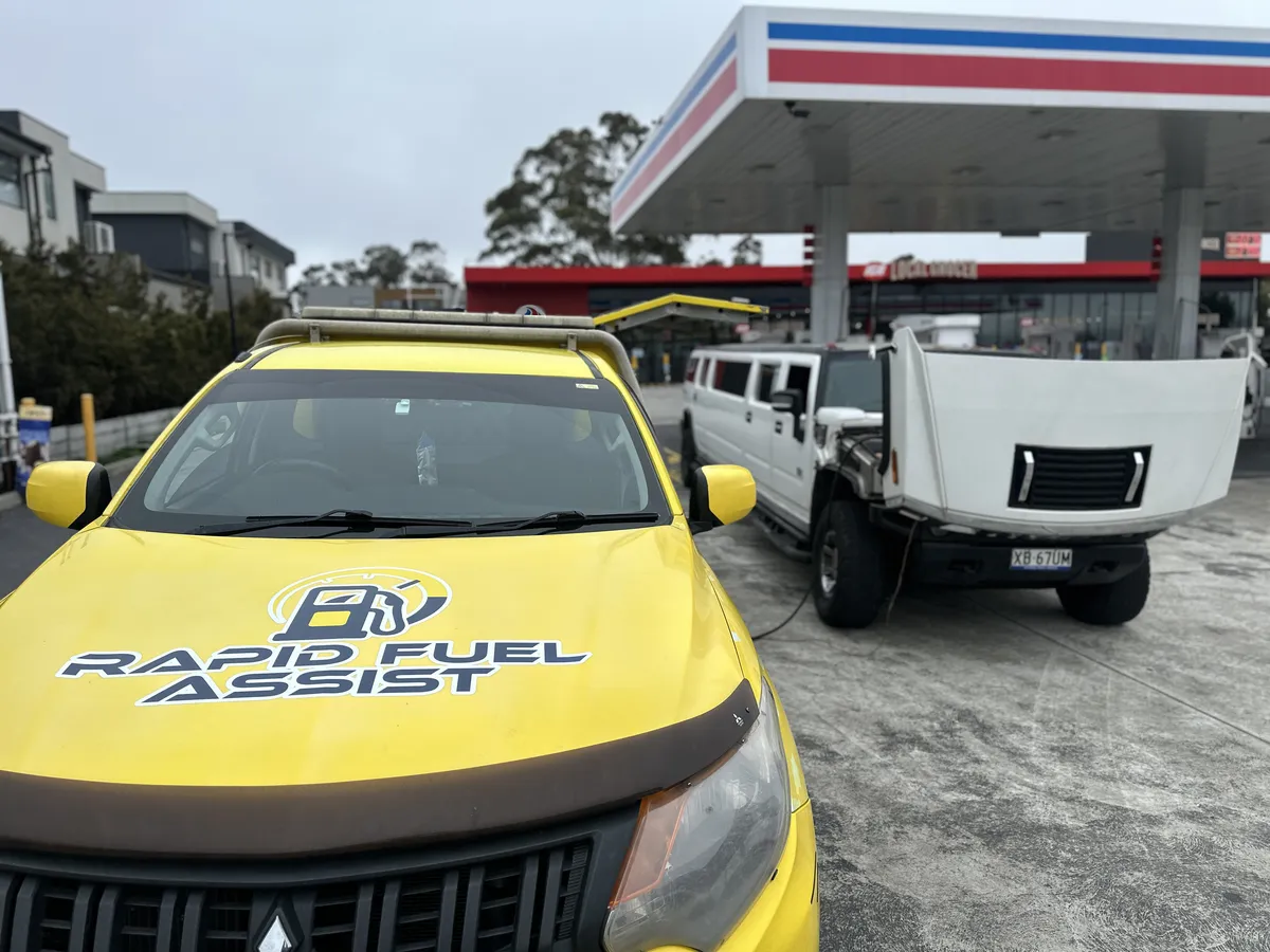Hummer H2 limo with the bonnet up while we drain diesel from the petrol tank at a Greenvale servo