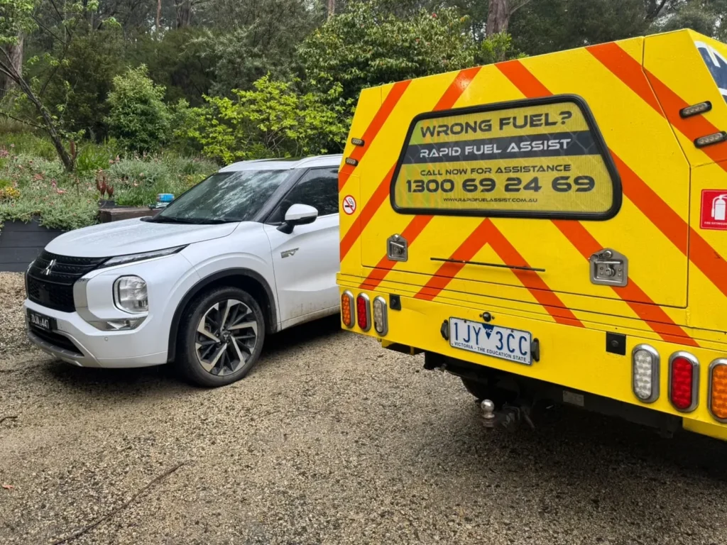 Mitsubishi Outlander PHEV with diesel in the petrol tank, beside the Rapid Fuel Assist ute at a home in Gembrook